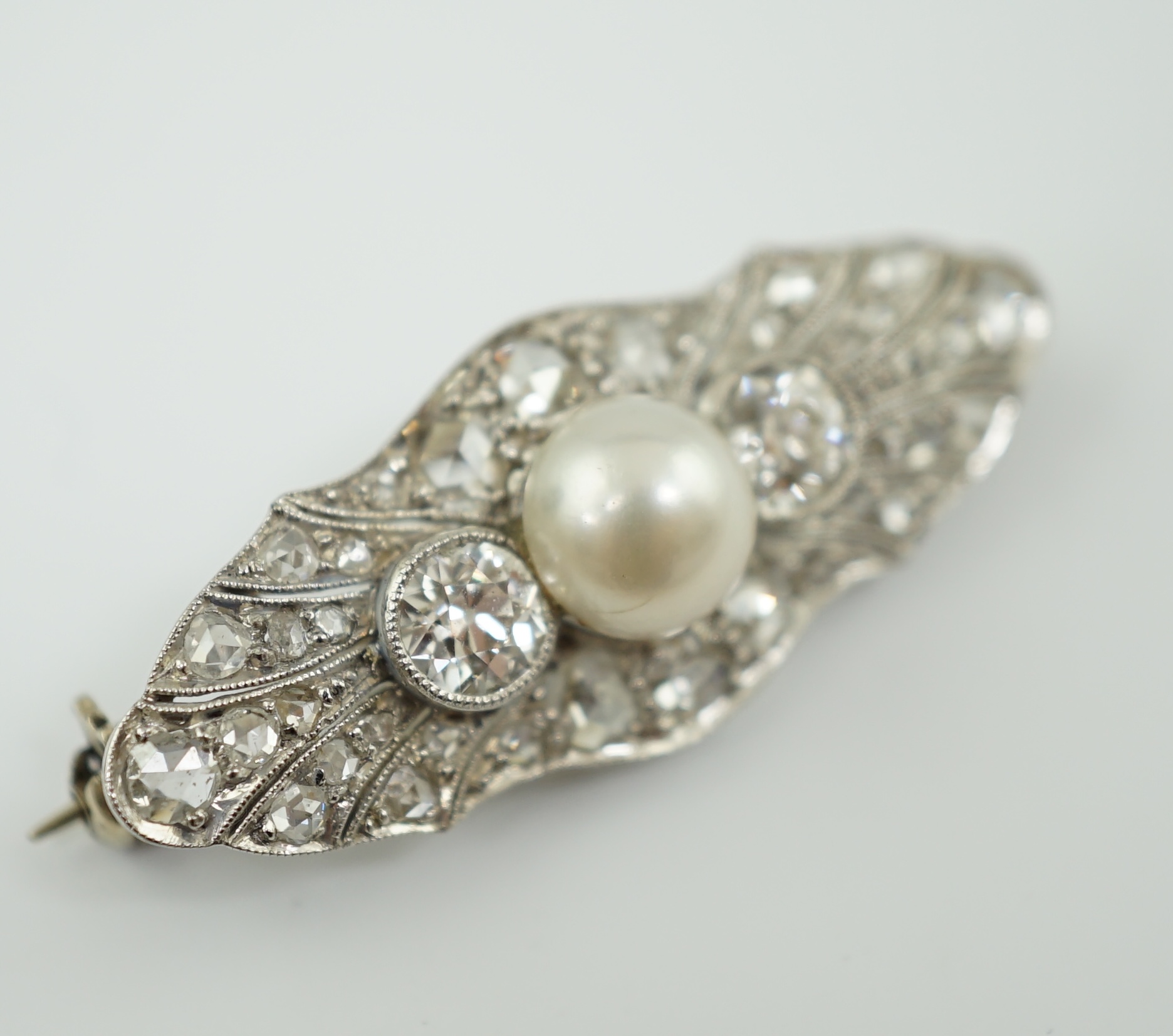 A Belle Epoque white gold, single stone split pearl and millegrain set diamond cluster lozenge shaped brooch